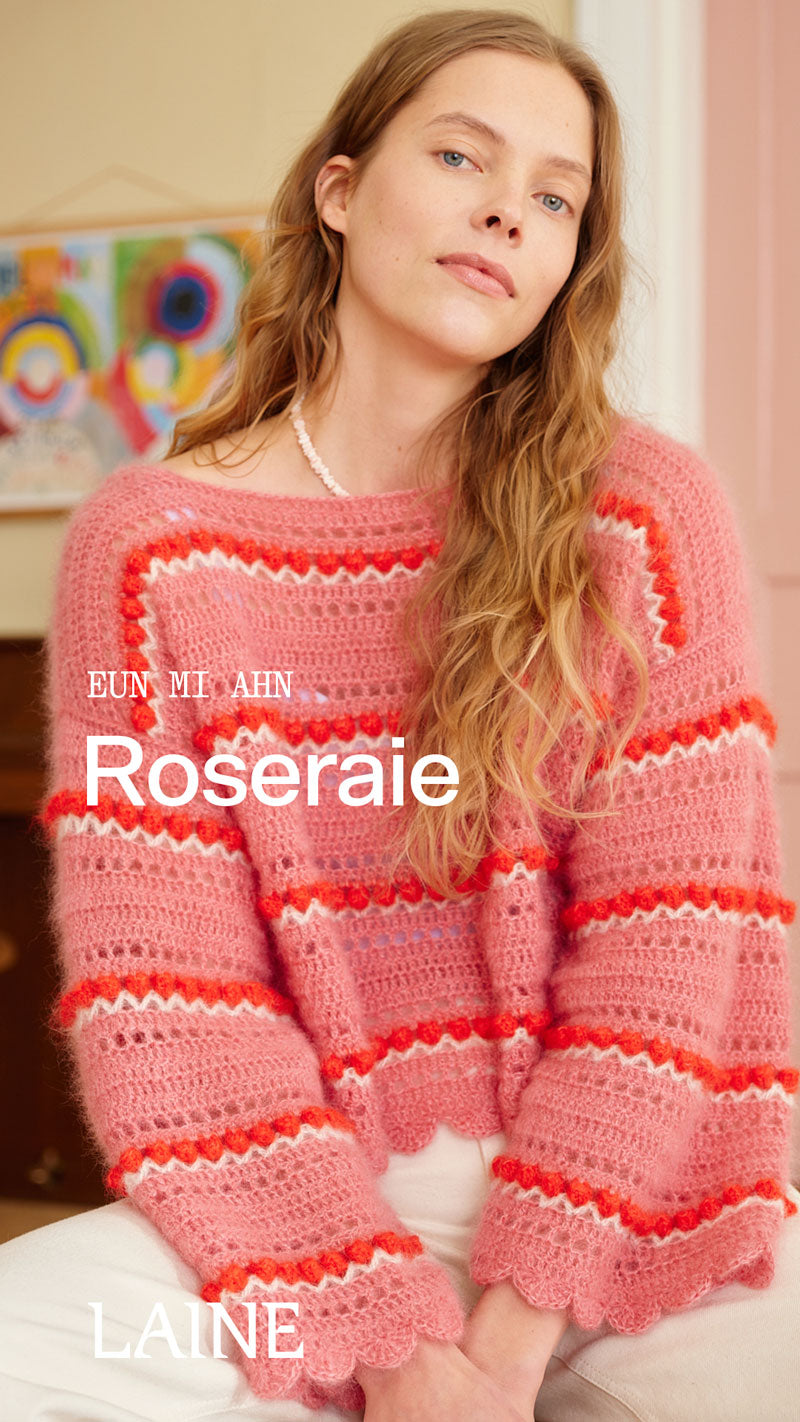 Frau mit gehäkeltem Oversized Pullover in rosa, weiß, rot gestreift. Mit Eyelet-Streifen und Bud-Stitch Details.