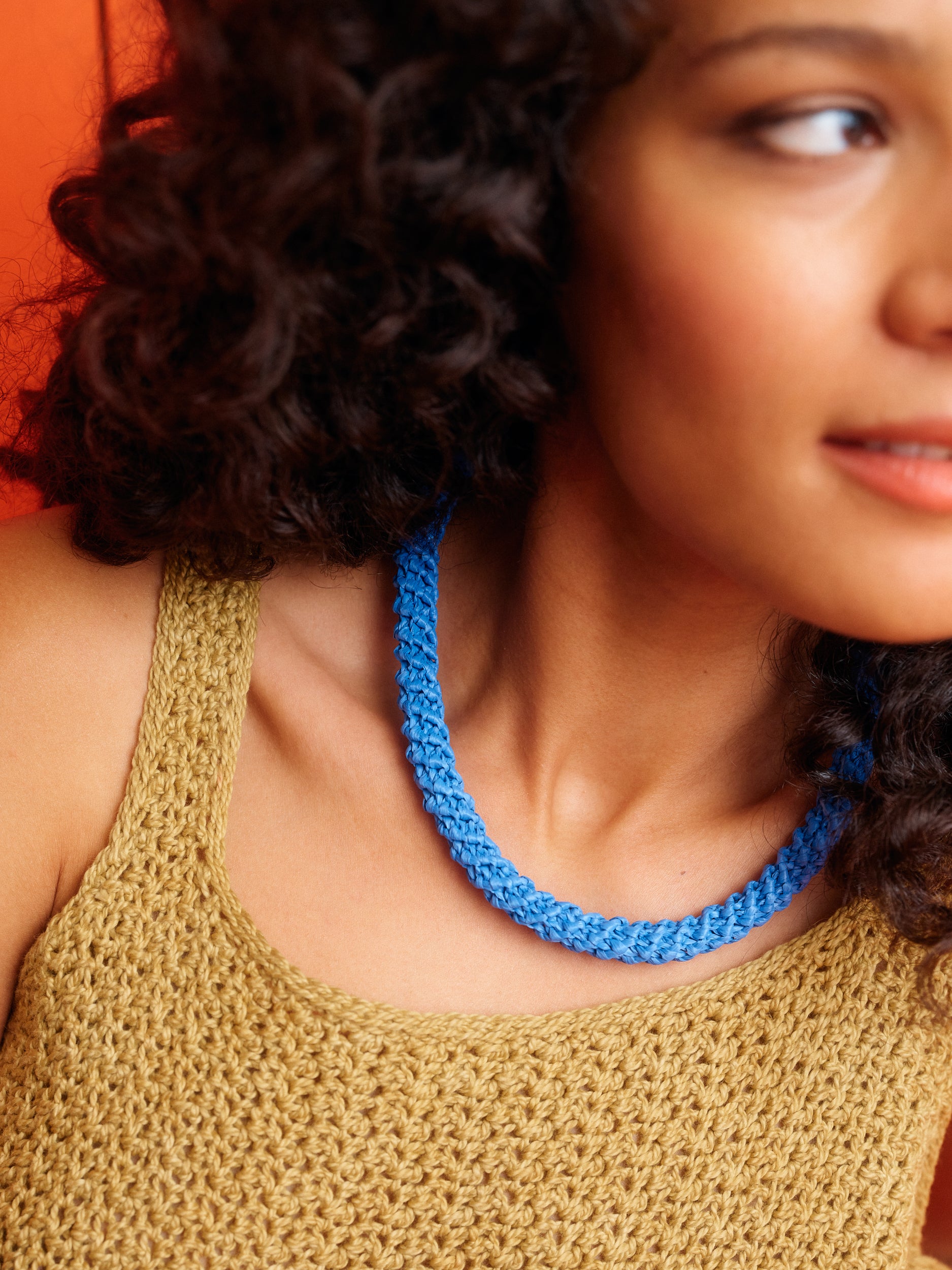 Frau mit blauem gehäkeltem Halsband