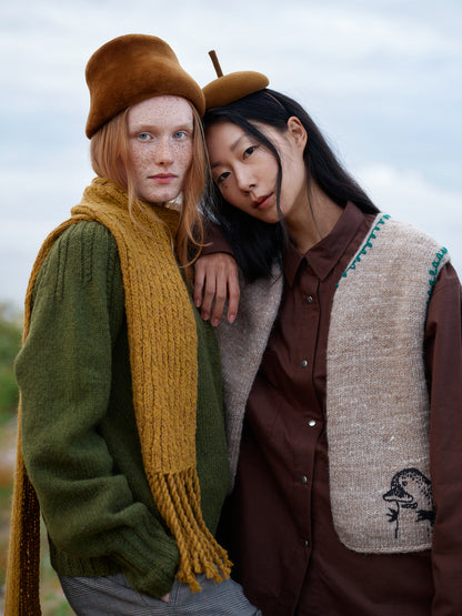 Frau mit Strickweste und Frau mit senfgelbem Strickschal